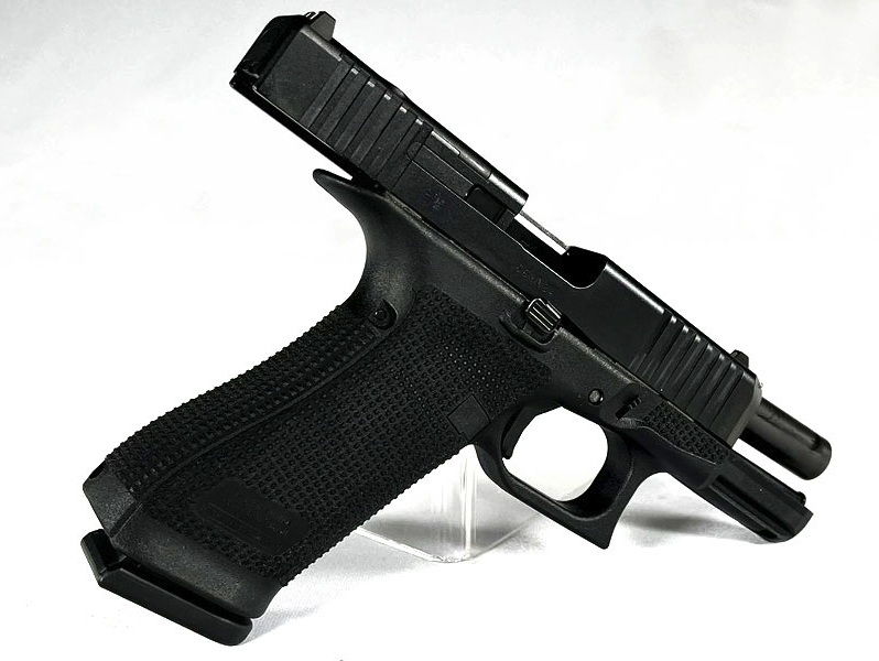 Glock 45 Gen6 OR 9mm Pistole in Schwarz, schraege Rueckansicht mit RTF6-Grifftextur und Magazinschacht vor weissem Hintergrund